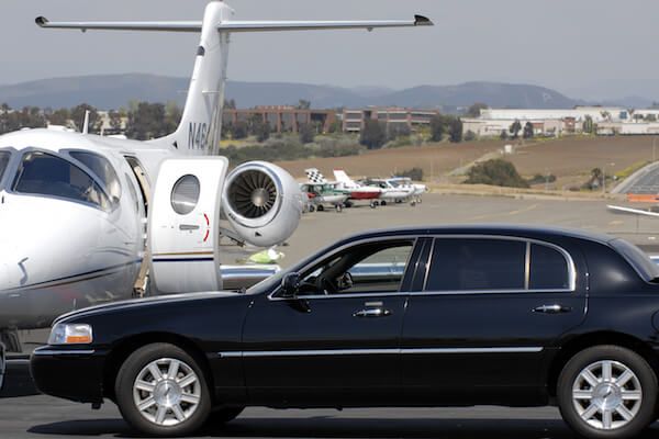 SEA Limo Service A limousine is parked next to a private jet