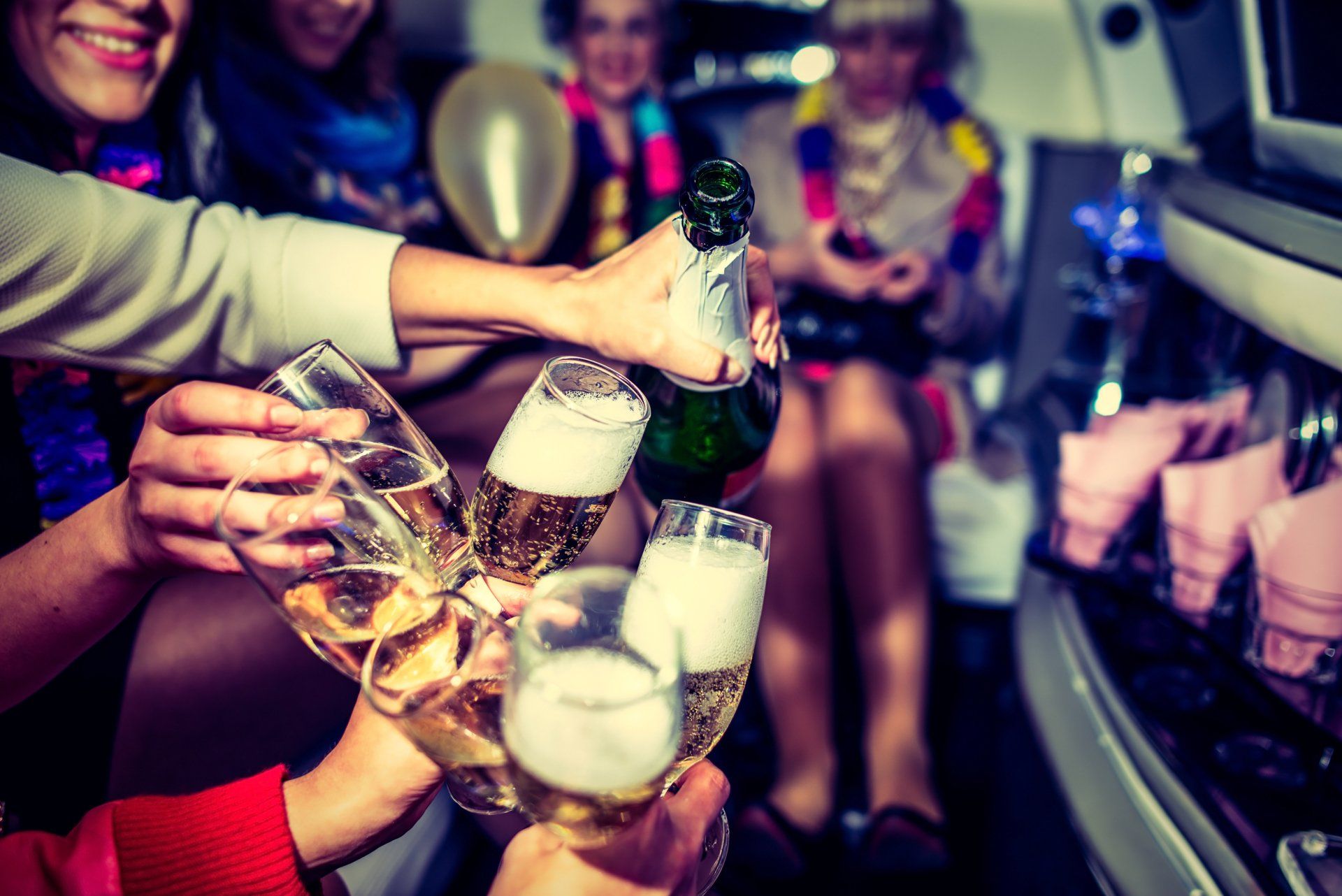 A group of people are toasting with champagne in a limousine.