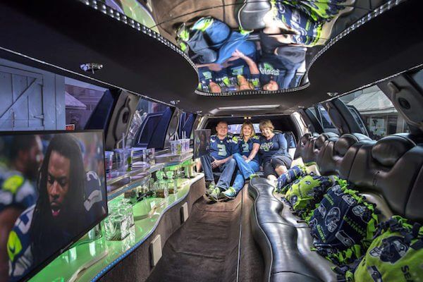 A group of people are sitting in a limo watching a football game.