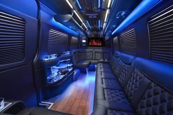 Corporate Limousine The inside of a limousine with blue lights and a flat screen tv.