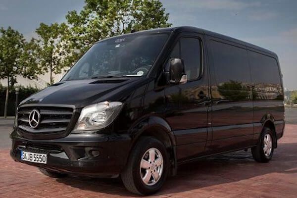 A black mercedes sprinter van is parked in a parking lot.