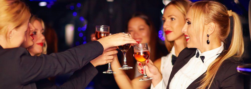 A group of women are toasting with champagne glasses at a party.