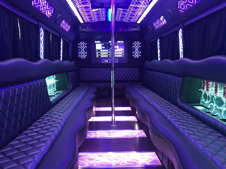 The inside of a purple limousine with a pole in the middle.