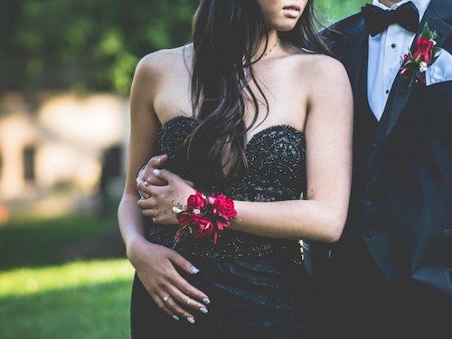 Luxury transportation services for prom A woman in a black dress is standing next to a man in a tuxedo.
