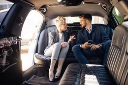 Limo Rentals A man and a woman are sitting in the back seat of a limousine.