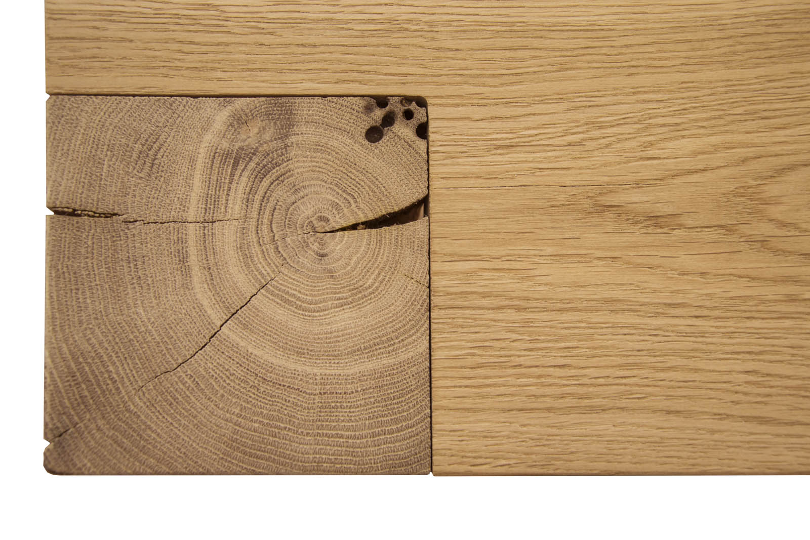 Primo piano di un giunto di una trave di legno, che mostra la venatura di testa con crepe e anelli di crescita visibili accanto alla venatura laterale liscia.