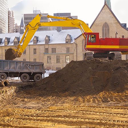 buldozer loading dirt onto a truck