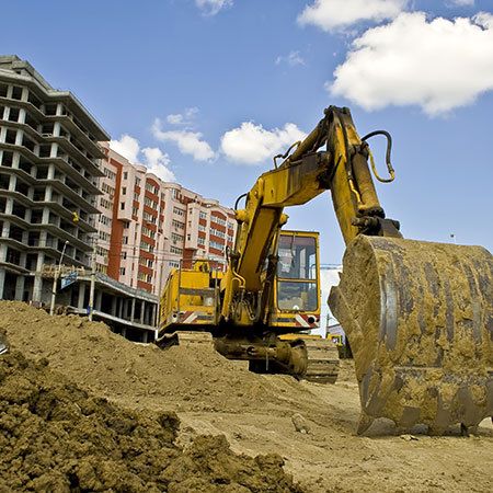 buldozer with unfinished appartment building in the background