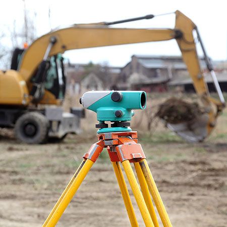 tripod with a buldozer in the background