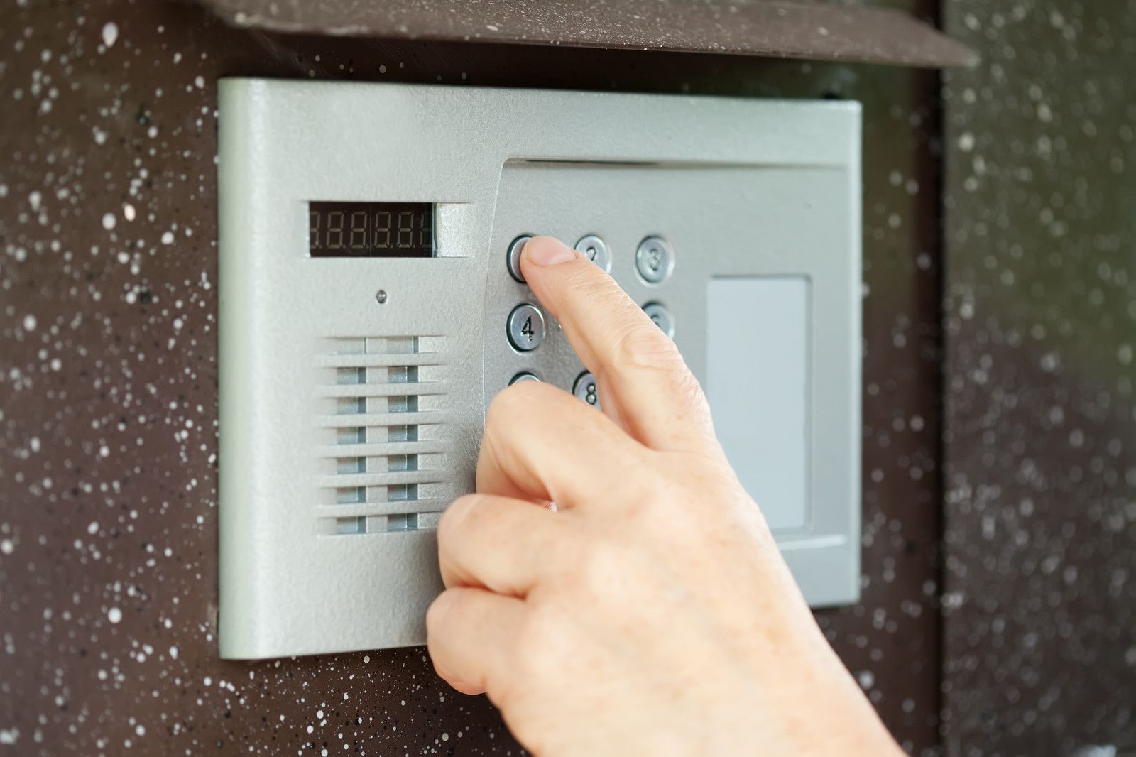 Someone pushing the buttons on a home security system