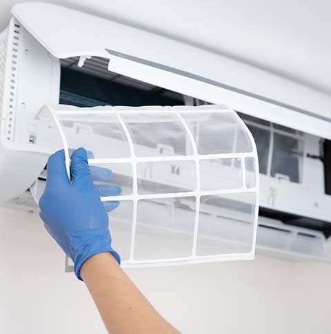 Technician Cleaning Air Condition Filter | Derry, NH | Derry Plumbing & Heating Technician Cleaning Air Condition Filter | Derry, NH | Derry Plumbing & Heating