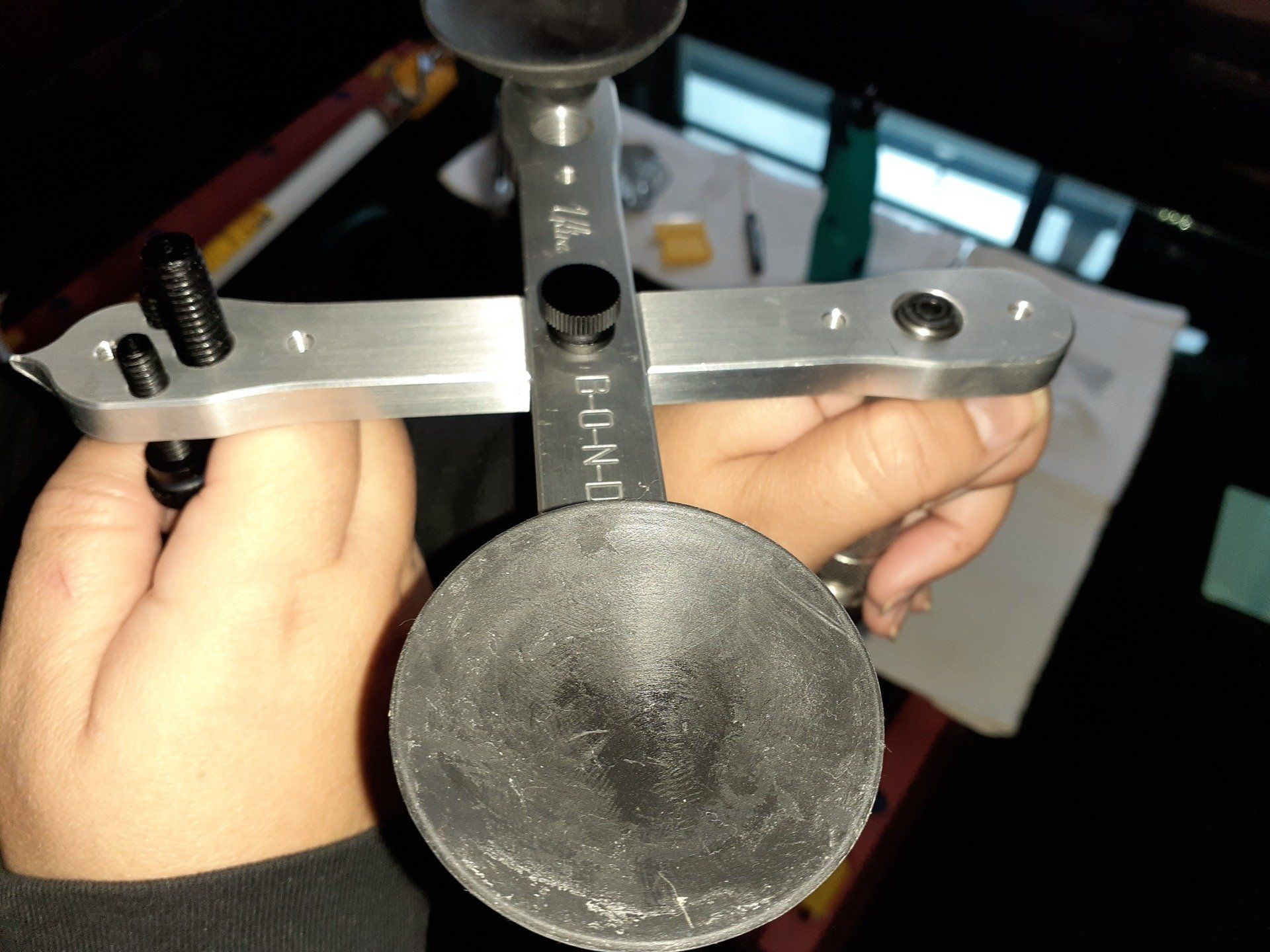 A person is holding a piece of metal that says ' jl ' on it