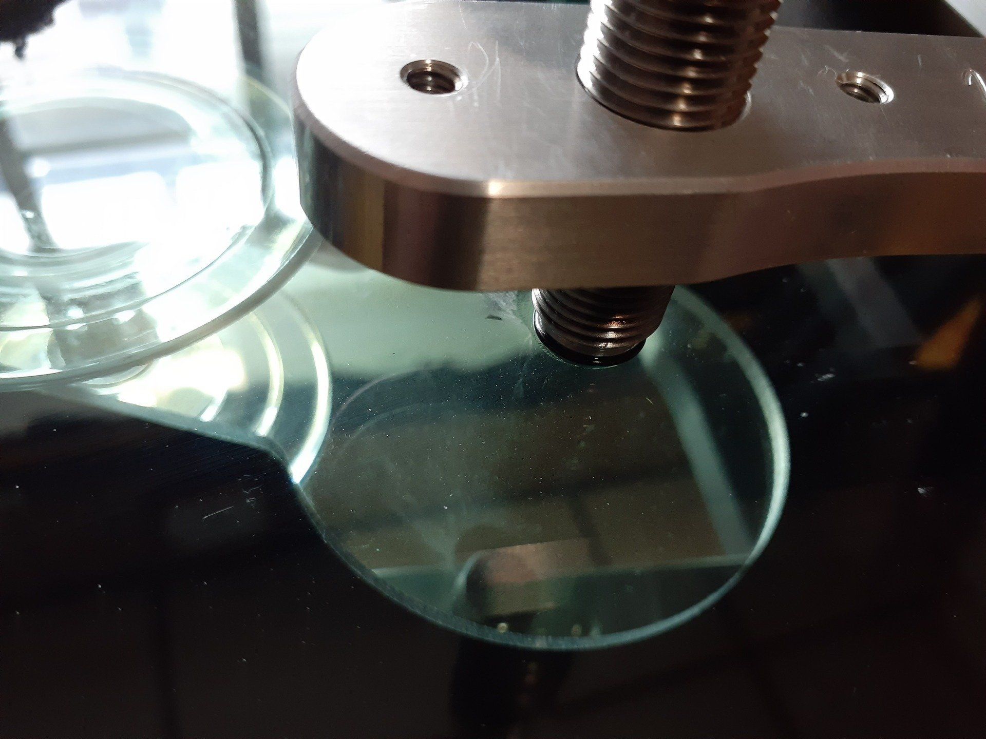 A close up of a metal object on a glass surface