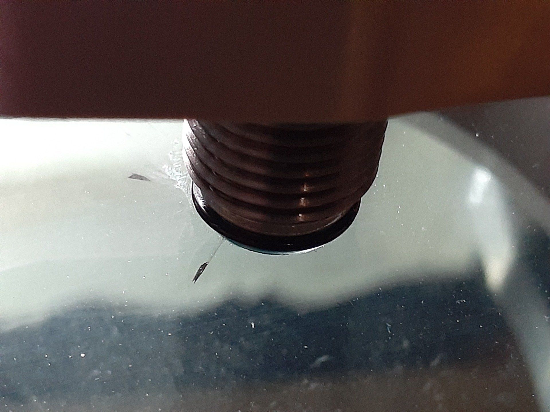 A close up of a screw on a glass surface