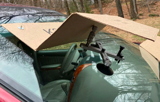 A cardboard box is sitting on top of a car windshield