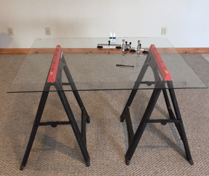 A glass table is sitting on top of a carpeted floor
