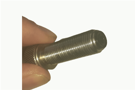 A person is holding a metal screw in their hand.