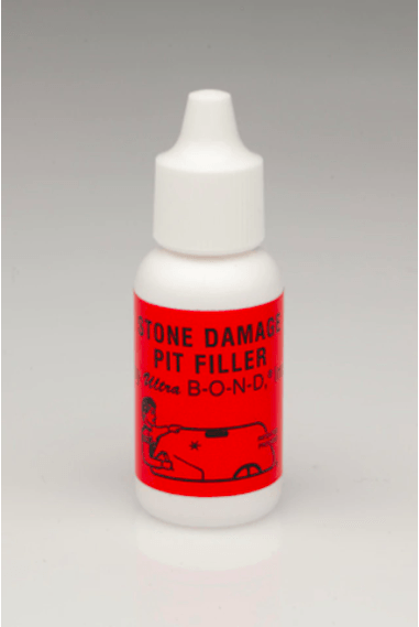 A white bottle with a red label that says stone damage pit filler