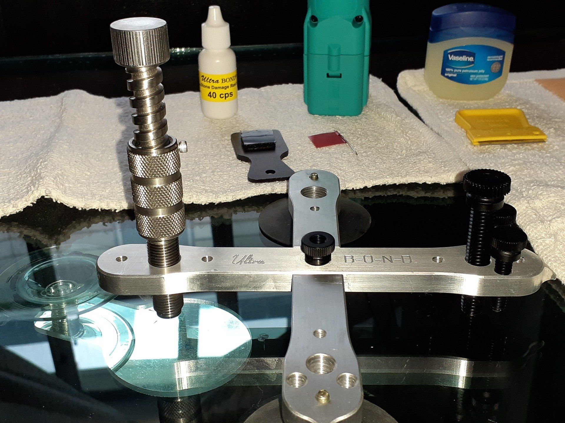 A bottle of vaseline sits next to a tool on a table