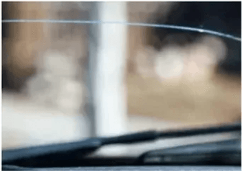 A close up of a windshield with a wiper on it.
