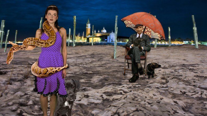 Woman with snake, dog, and man with umbrella, dog in Venice at night.
