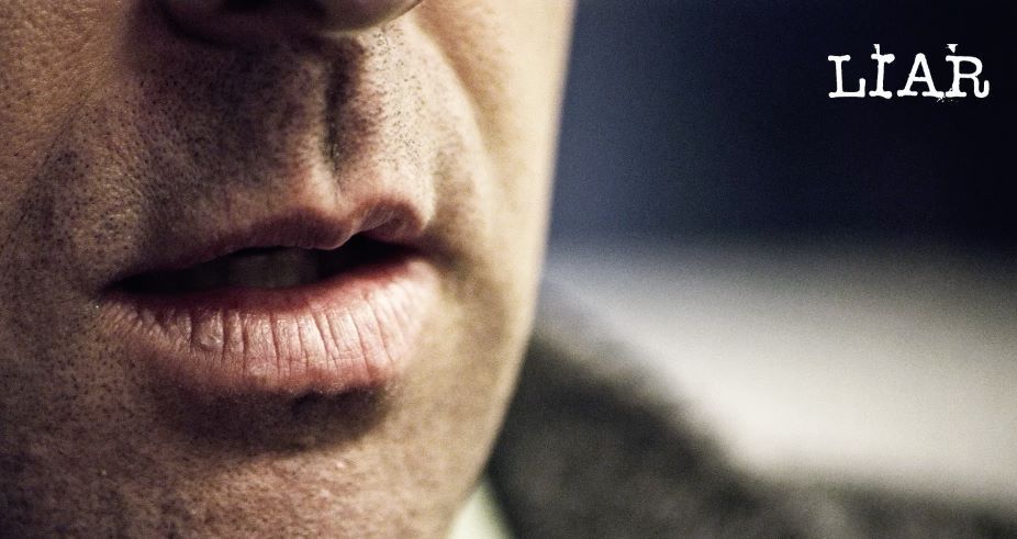 Close-up of a man's mouth, with the word