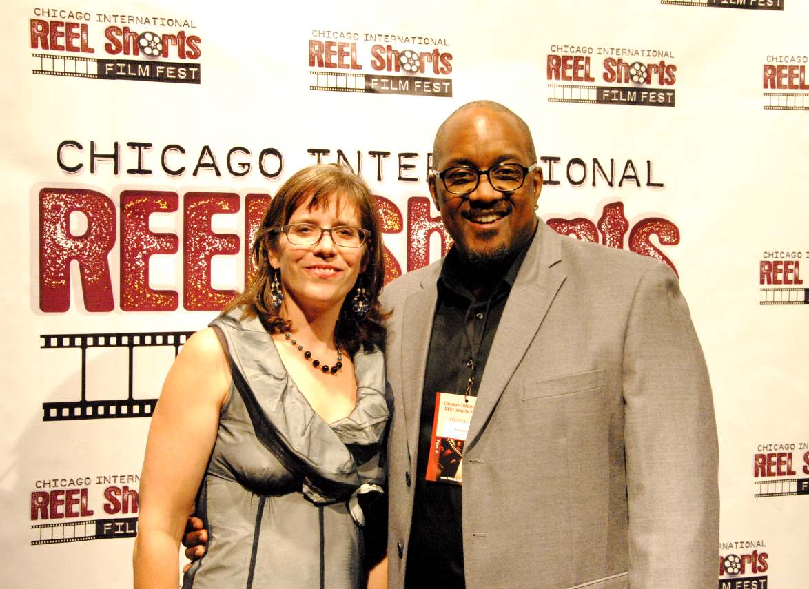 Woman and man at Chicago International Reel Shorts Film Fest; woman has glasses, the man has a jacket and name badge.