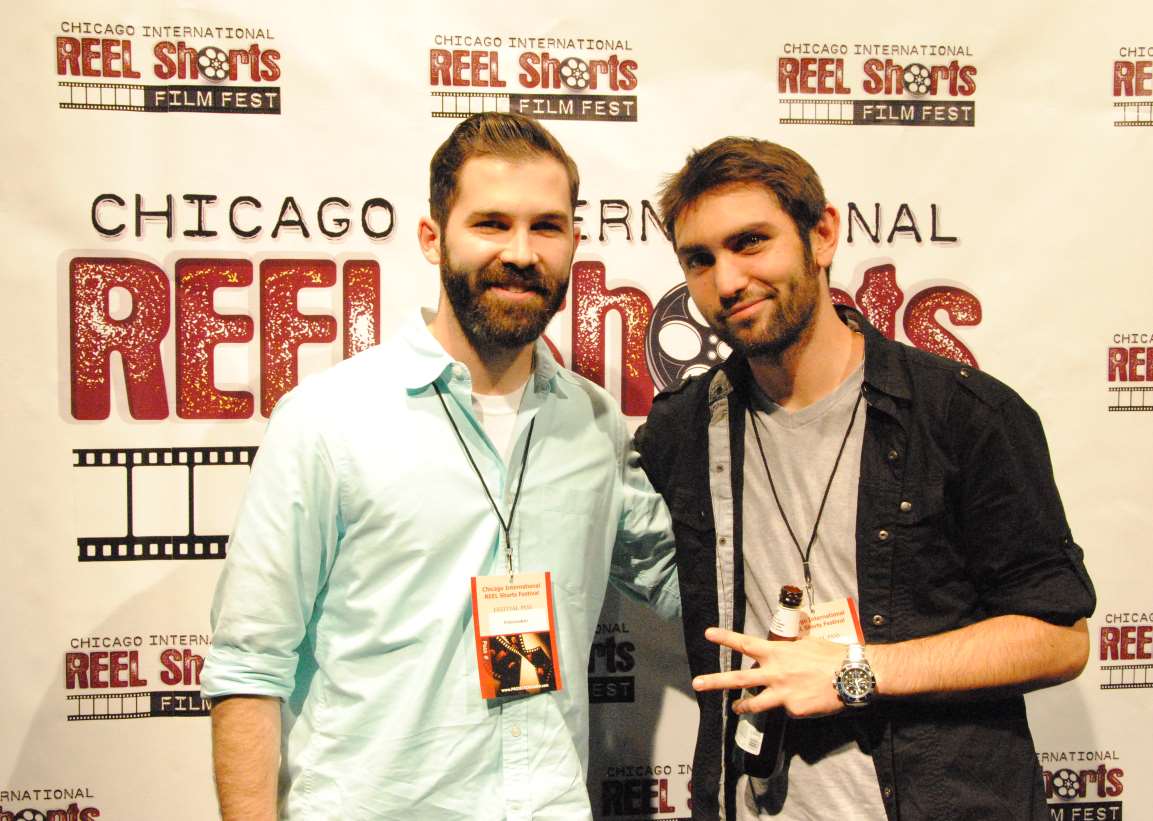 Two men at the Chicago International REEL Shorts festival. One man poses with the peace sign.