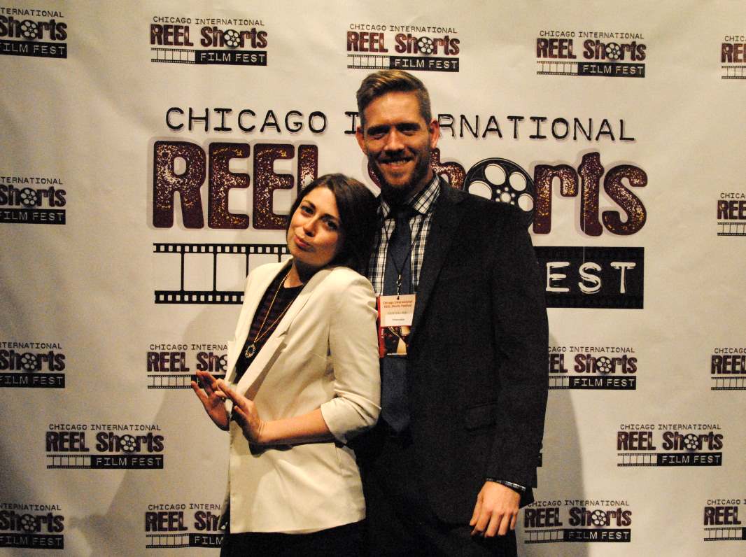 A woman and a man pose at the Chicago International Reel Shorts Film Fest. The woman gestures playfully.