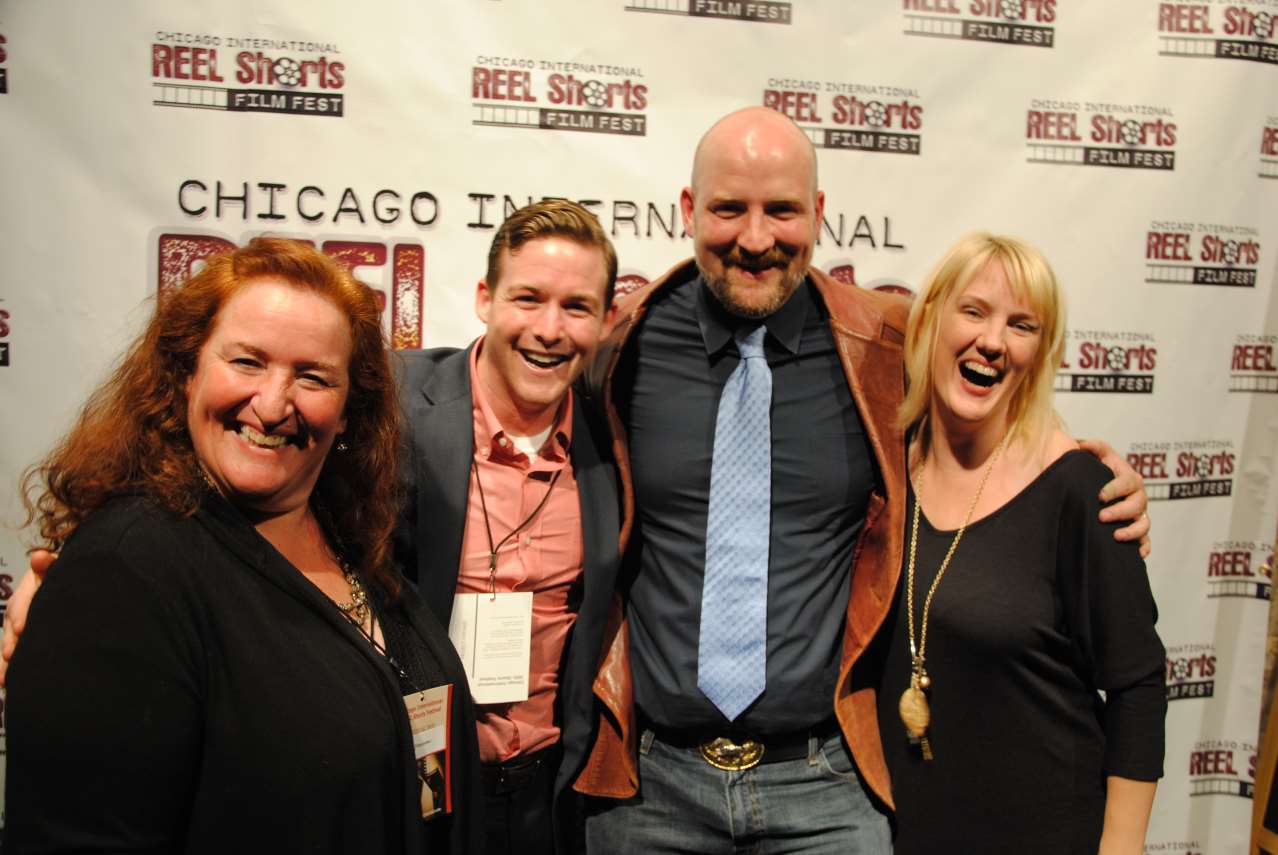 Four people smiling at the Chicago International REEL Shorts Film Fest. Two women and two men, mostly in dark colors.