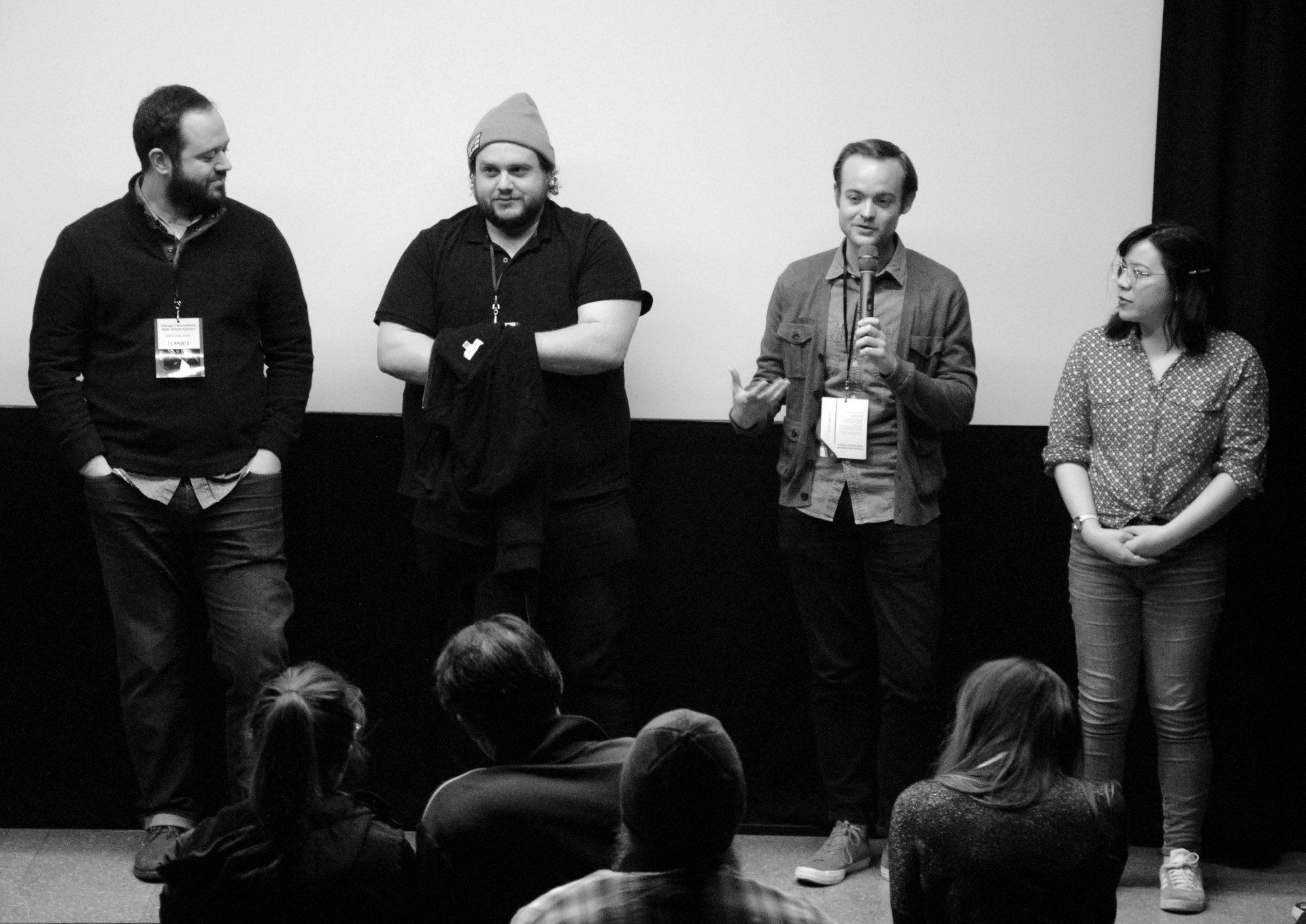 Panel of four people speaking in front of an audience, likely a film screening.