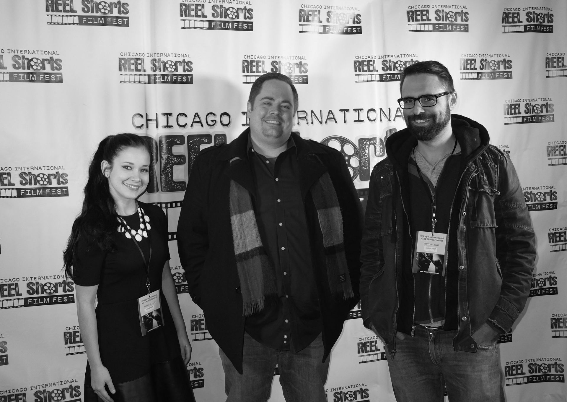 Three people pose in front of a Chicago International Reel Shorts banner.
