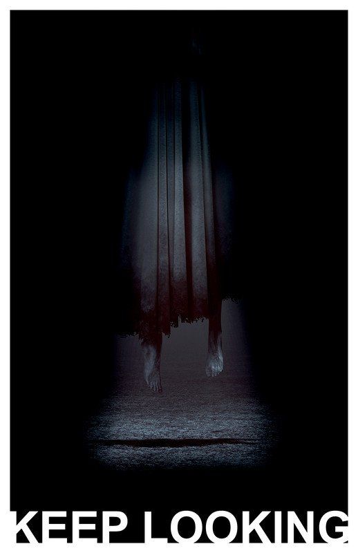 A shadowy figure in a white sheet hangs in a dark space.