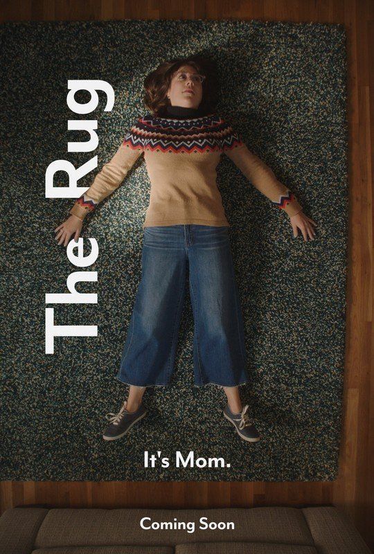 Woman lying on a green rug, wearing a sweater and jeans. Text reads:
