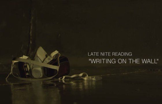 A bag and glasses sit on a wet floor against a dark wall. Text reads