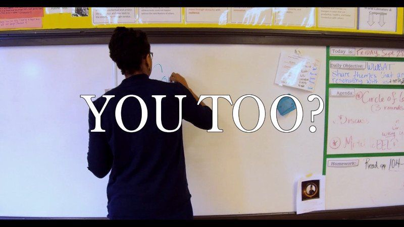 Teacher writing on whiteboard in classroom,