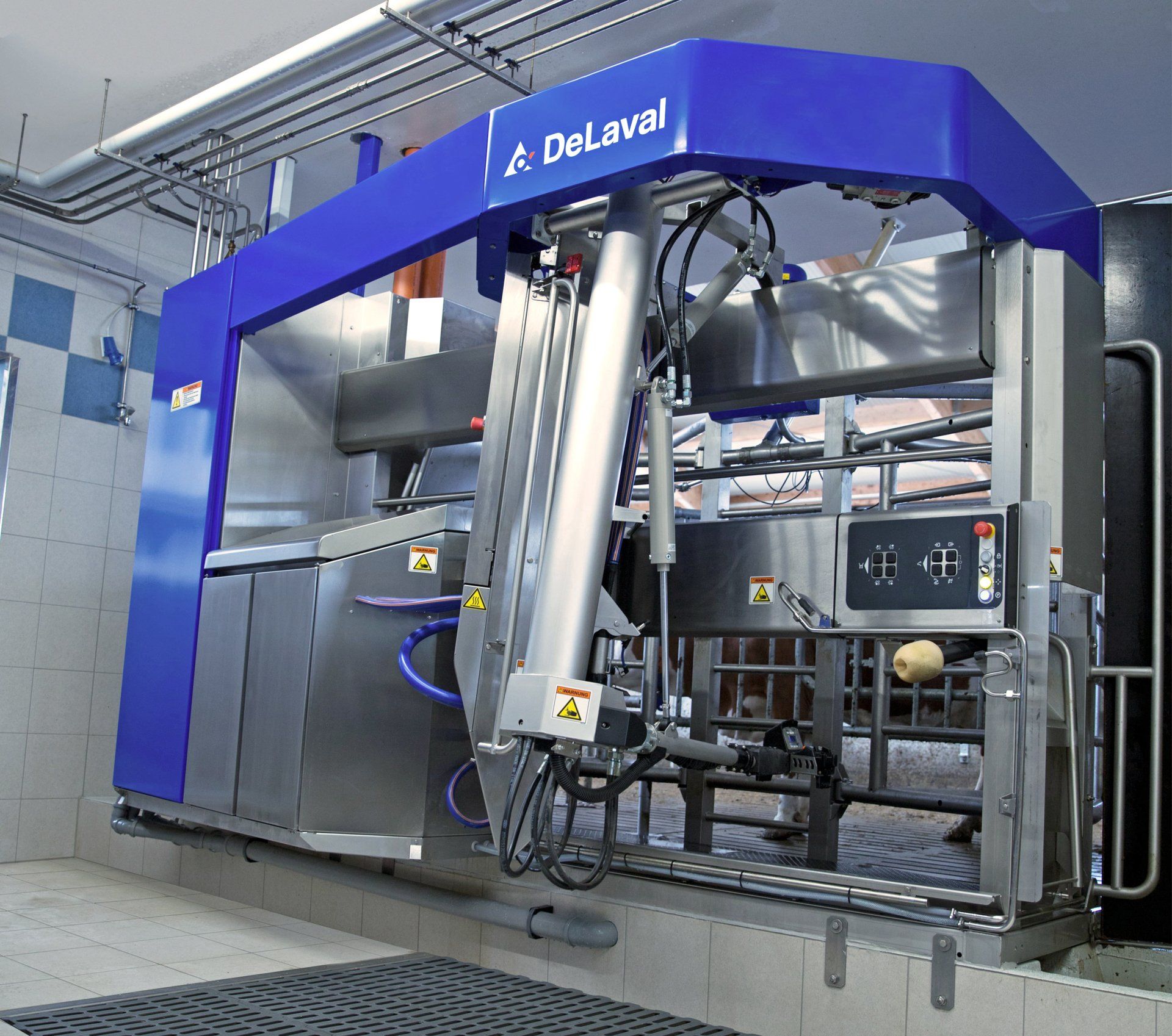 Grote blauw-zilveren DeLaval-industriemachine in een betegelde werkplaatsruimte.