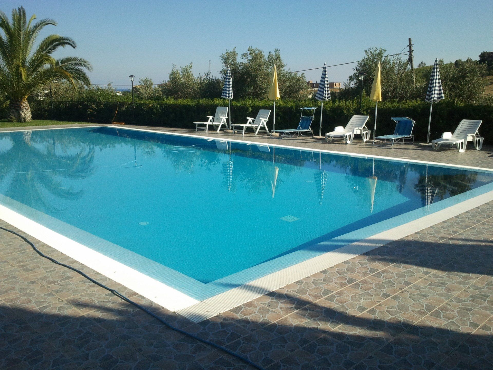 Una piscina rettangolare piena di acqua azzurra. 