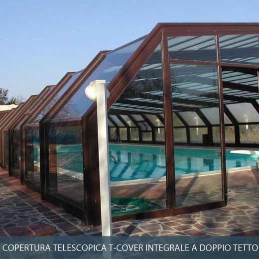 Copertura telescopica per piscina con struttura in legno marrone e pannelli in vetro.