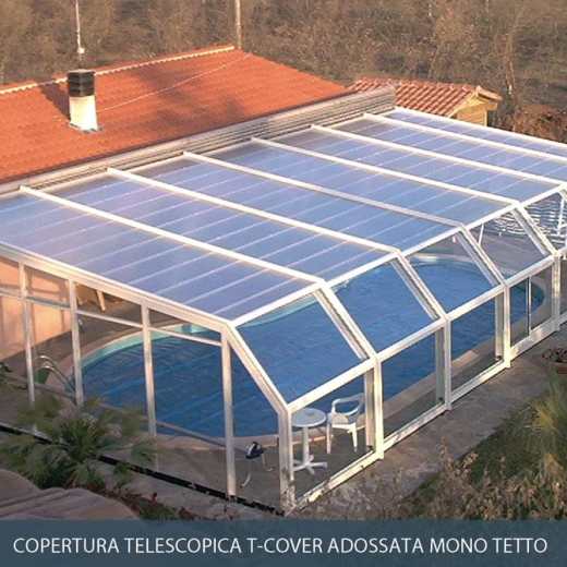 Copertura per piscina con tetto e pannelli laterali traslucidi, fissata a una casa con tetto di tegole rosse.
