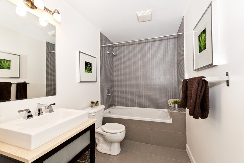 bathroom with toilet next to tub and small sink
