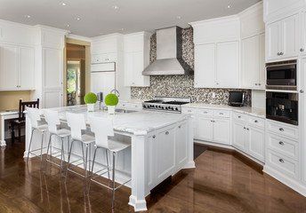 white kitchen with grey brick and an island