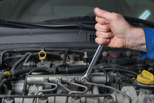 due mani con un cacciavite a t che avvitano un bullone del motore due mani con un cacciavite a t che avvitano un bullone del motore
