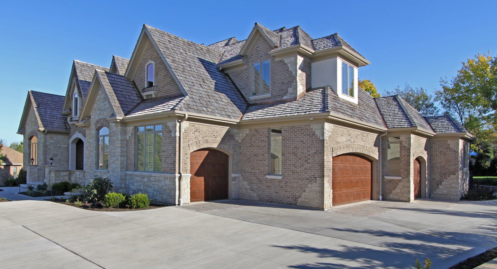 A large brick house with a large driveway in front of it