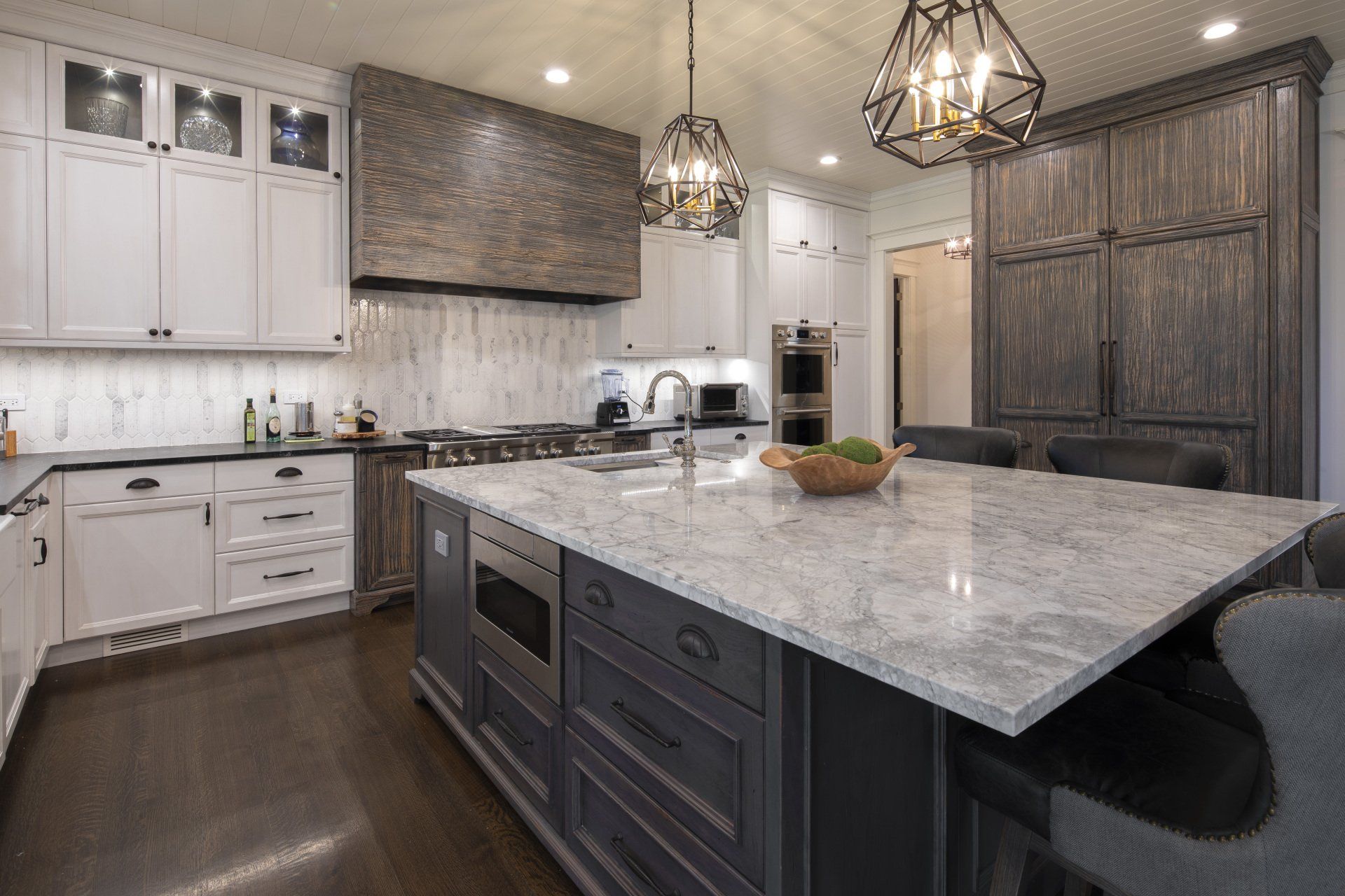 A kitchen with white cabinets and a large island in the middle.