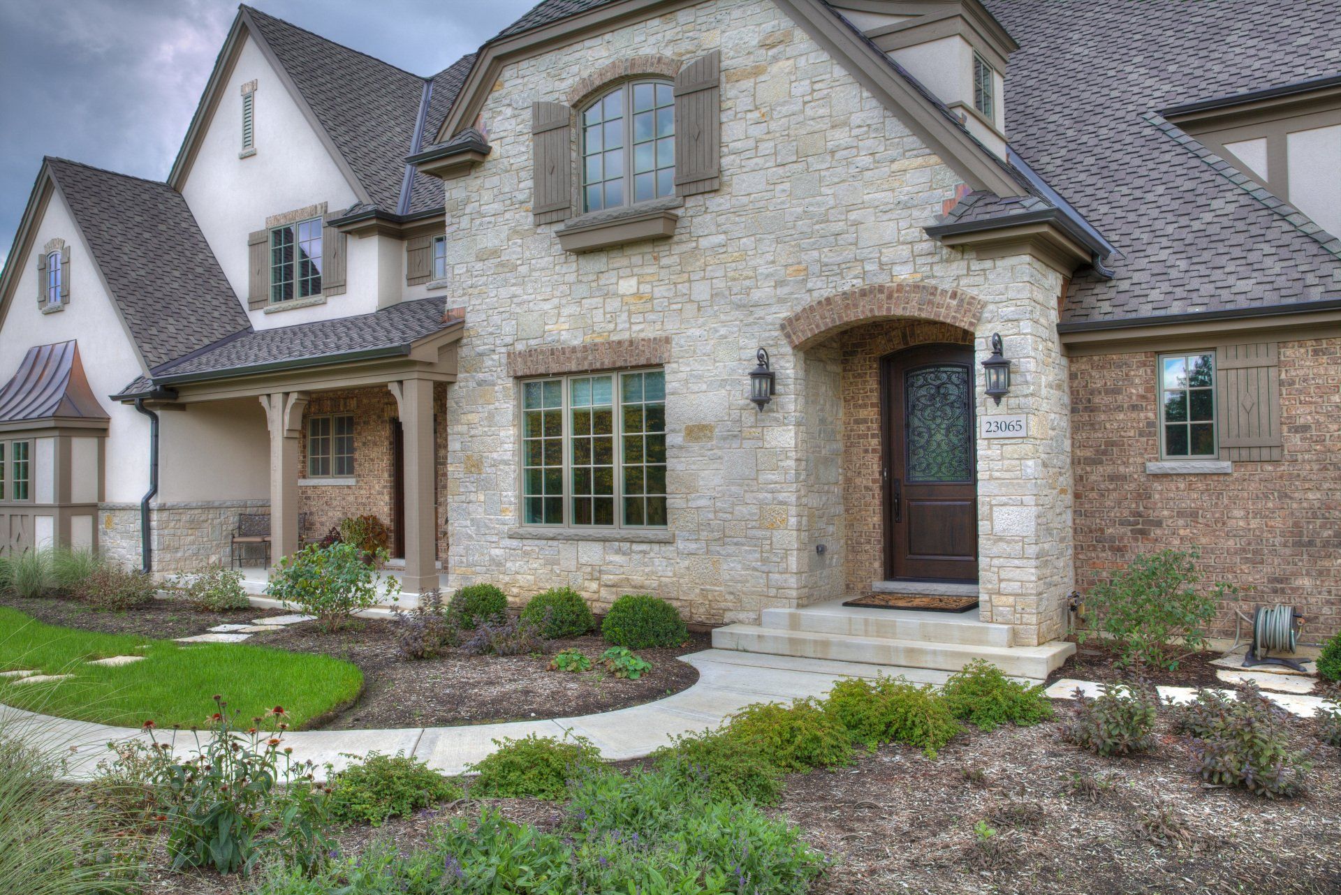 A large brick house with a gray roof and a black door