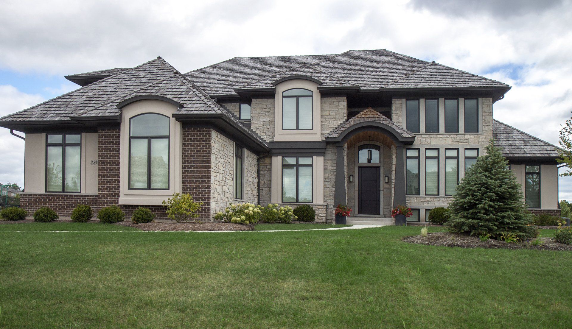A large house with a lot of windows and a black door