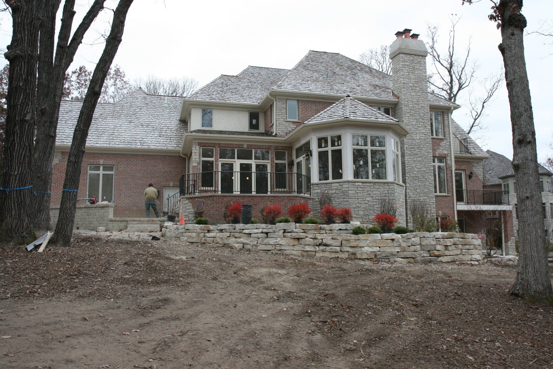 A large brick house with a stone chimney in the backyard
