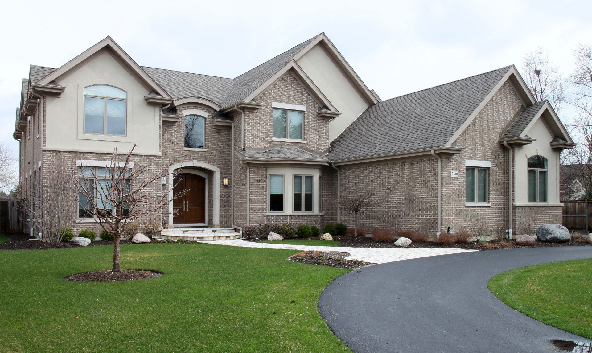 A large brick house with a driveway leading to it