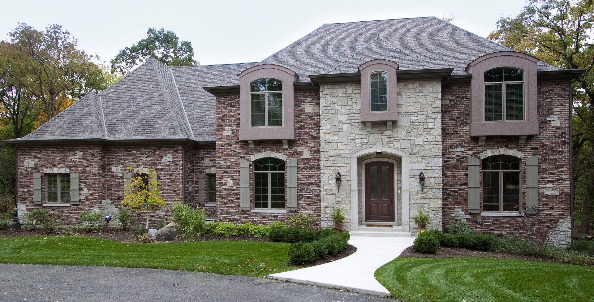 A large brick house with a gray roof and many windows